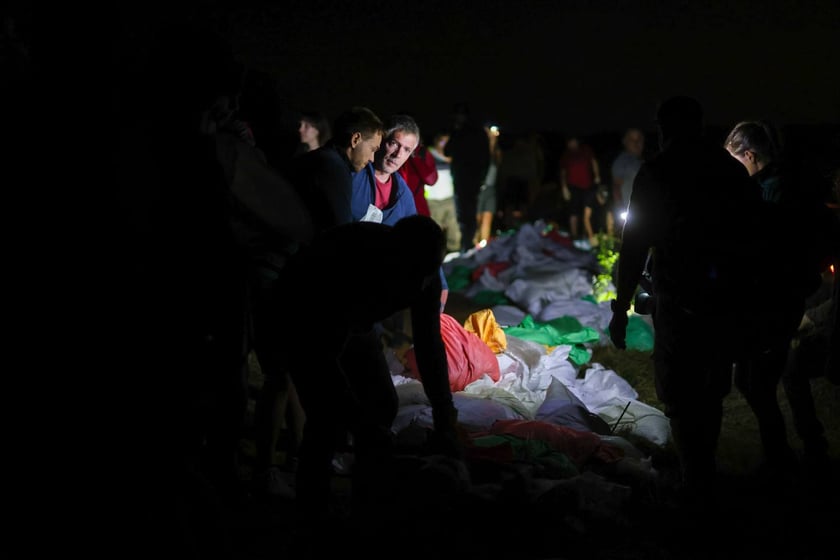 Kobiety i mężczyźni podczas akcji  na wale Janówek - Pracze. Trwa jego uszczelnianie