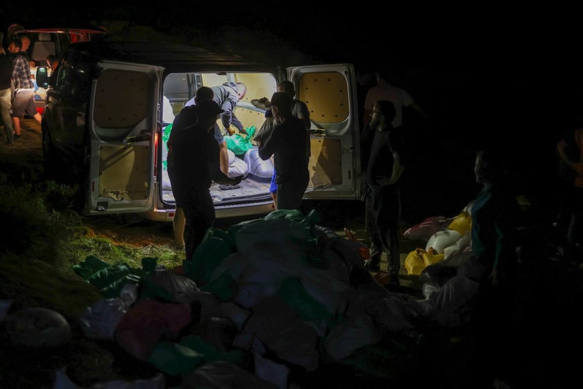 Kobiety i mężczyźni podczas akcji  na wale Janówek - Pracze. Trwa jego uszczelnianie