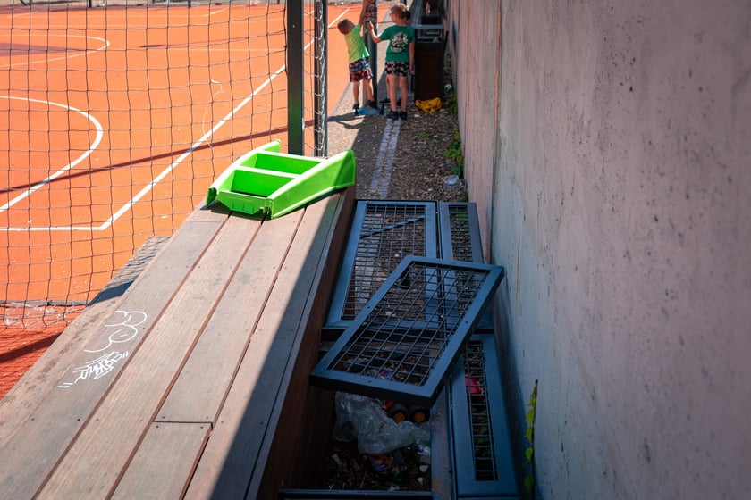 Podw&oacute;rko Wszystkich Mieszkańc&oacute;w - z krat zabezpieczających wykręcono wszystkie śruby, a w przestrzenie pod nimi nawrzucano śmieci