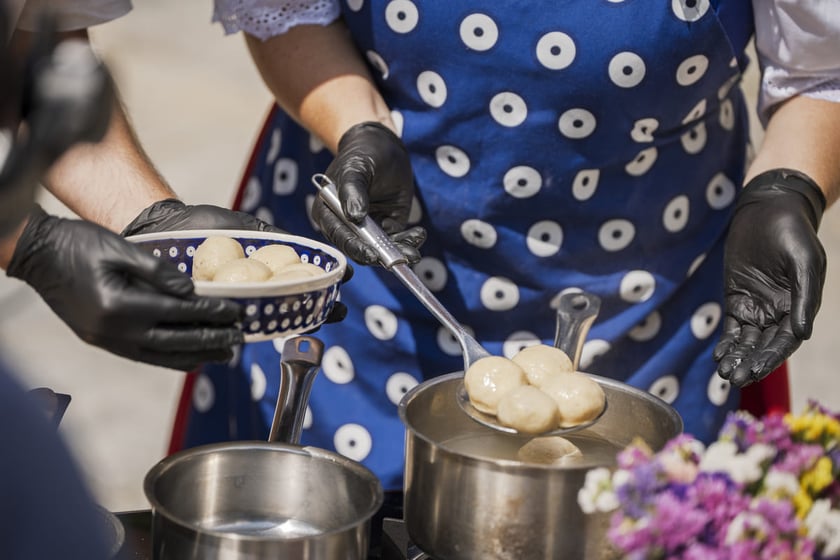 Kamila Kokot i Tomasz Sielicki pokazują, jak ugotować kluski wrocławskie. Zdjęcie wykonano 23 lipca 2025 na Ostrowie Tumskim, w trakcie kręcenia filmu.