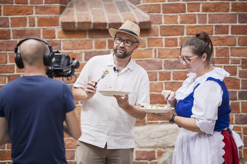 Kamila Kokot i Tomasz Sielicki pokazują, jak ugotować kluski wrocławskie. Zdjęcie wykonano 23 lipca 2025 na Ostrowie Tumskim, w trakcie kręcenia filmu.