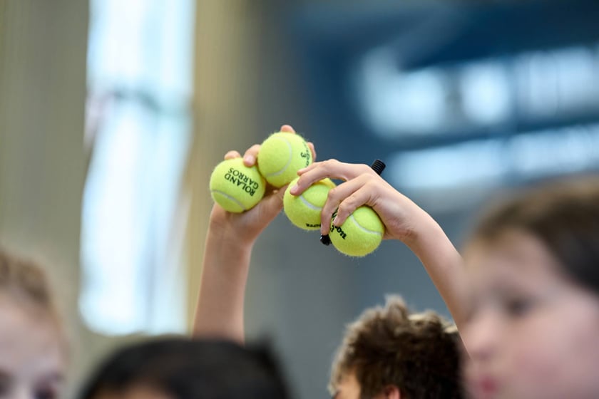 Piłki tenisowe dla 10 uczni&oacute;w zostały podpisane przez Hurkacza podczas spotkania