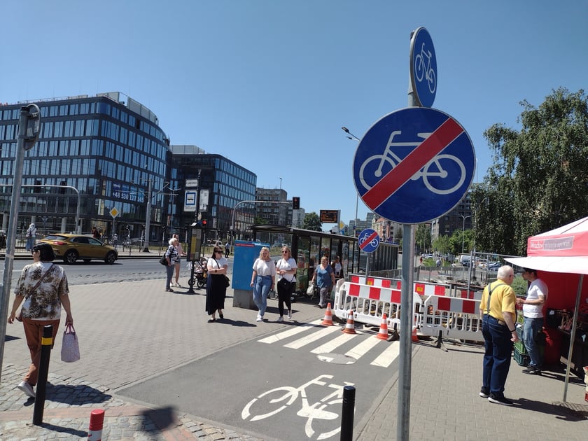 Głębokie wykopy w drodze rowerowej i plac budowy obok