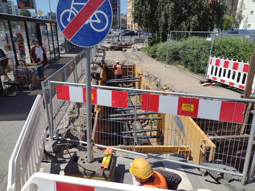 Głębokie wykopy w drodze rowerowej i plac budowy obok