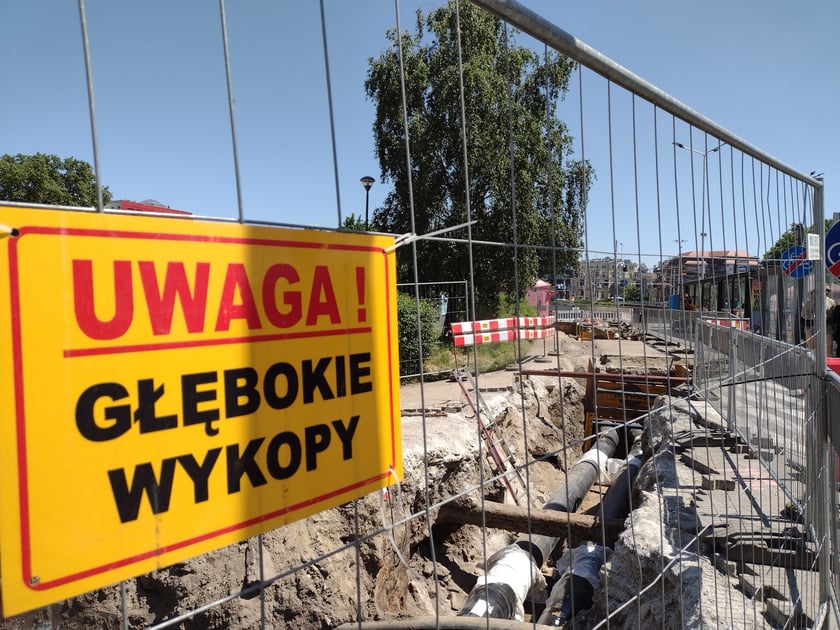 Głębokie wykopy w drodze rowerowej i plac budowy obok