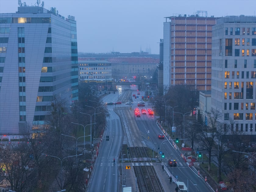 Powiększ obraz: Widok z lotu ptaka na dwujezdniową ulicę, z torowiskiem tramwajowym po środku i budynki stojące przy niej. Wyremontowany fragment ul. Powstańców Śląskich.
