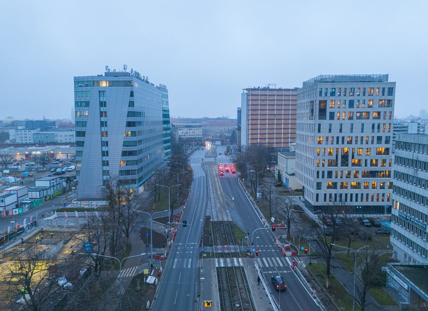Powiększ obraz: Widok z lotu ptaka na dwujezdniową ulicę, z torowiskiem tramwajowym po środku i budynki stojące przy niej. Wyremontowany fragment ul. Powstańców Śląskich.