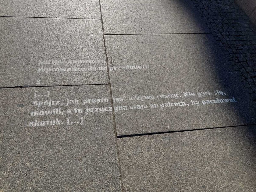Na zdjęciu fragment wiersza napisany na płytach chodnika