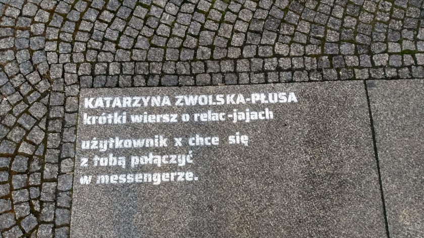 Na zdjęciu fragment wiersza napisany na płytach chodnika