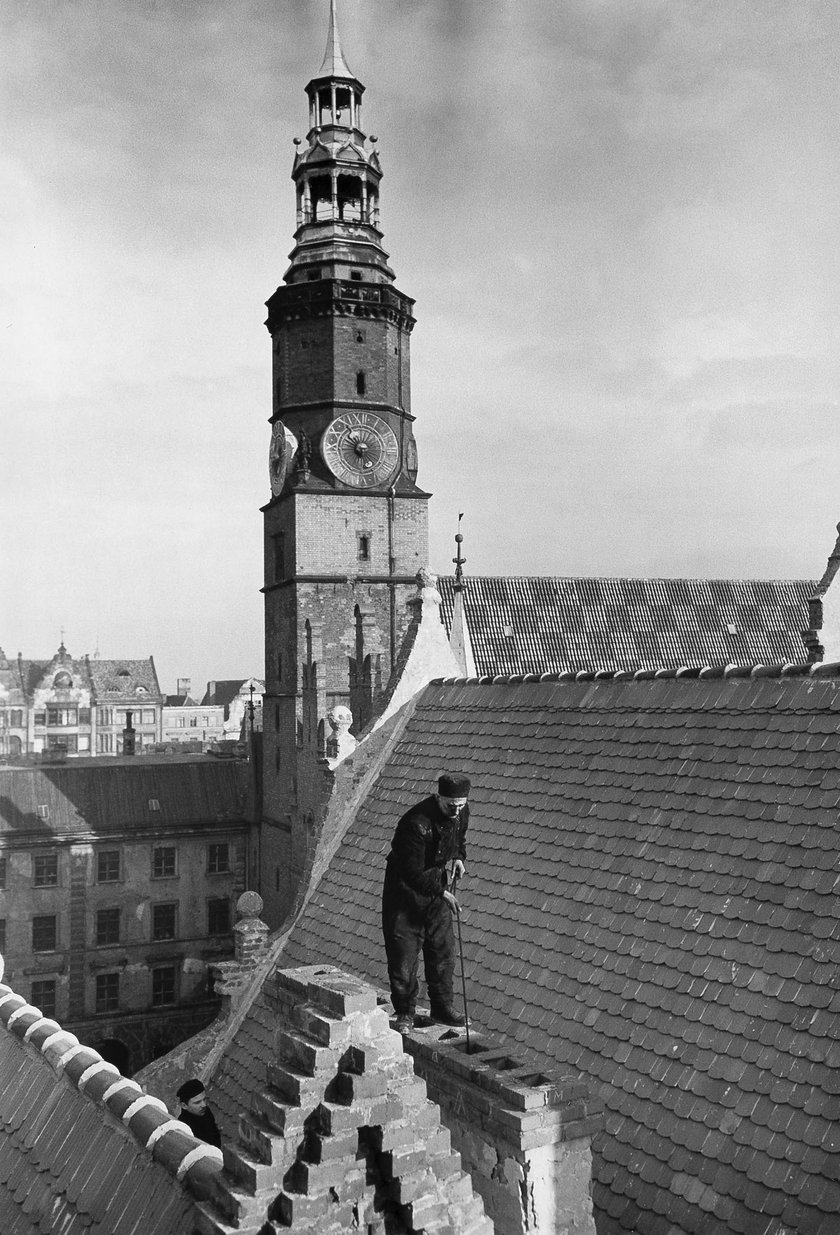 Pierwszy kominiarz na dachu odbudowanej kamieniczki w Rynku, luty 1955