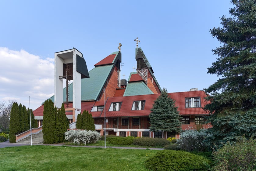 Kości&oacute;ł pw. Chrystusa Kr&oacute;la budowany był w latach 1978-1991 na planie kwadratu. Budowla przypomina ostrosłup złożony z czterech części, podobnych do wież, o zr&oacute;żnicowanej wysokości. Zbiegające się &nbsp;ku środkowi ściany owych wież przykrywają centralną (sakralną) część budowli, nadając jej ekspresyjny charakter. Nachylone połacie zdobi dekoracja przypominająca strukturę kryształu. W przyziemiu mieści się kaplica św. Mikołaja, ośrodek kultury i szkoła.