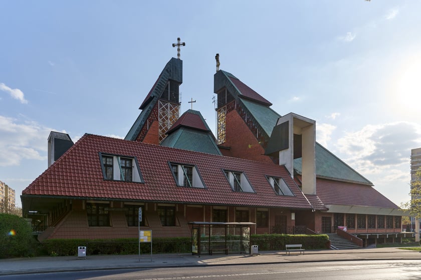 Kości&oacute;ł pw. Chrystusa Kr&oacute;la budowany był w latach 1978-1991 na planie kwadratu. Budowla przypomina ostrosłup złożony z czterech części, podobnych do wież, o zr&oacute;żnicowanej wysokości. Zbiegające się &nbsp;ku środkowi ściany owych wież przykrywają centralną (sakralną) część budowli, nadając jej ekspresyjny charakter. Nachylone połacie zdobi dekoracja przypominająca strukturę kryształu. W przyziemiu mieści się kaplica św. Mikołaja, ośrodek kultury i szkoła.