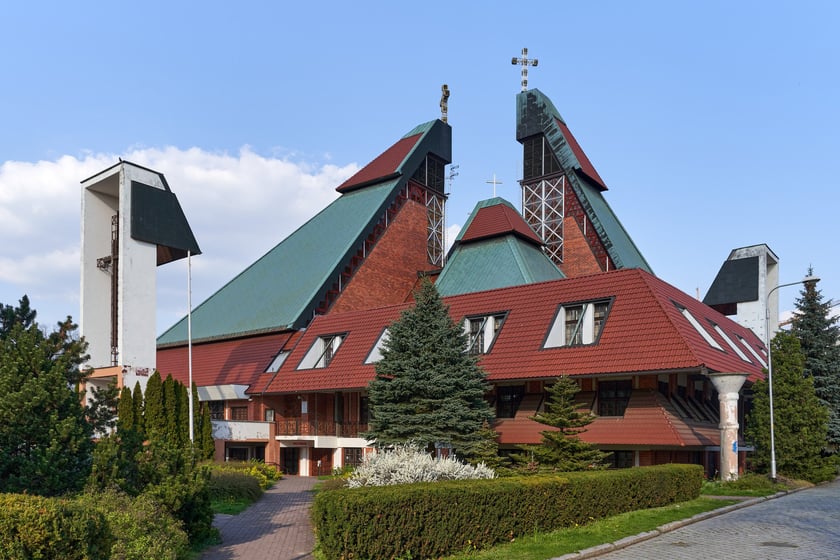 Kości&oacute;ł pw. Chrystusa Kr&oacute;la budowany był w latach 1978-1991 na planie kwadratu. Budowla przypomina ostrosłup złożony z czterech części, podobnych do wież, o zr&oacute;żnicowanej wysokości. Zbiegające się &nbsp;ku środkowi ściany owych wież przykrywają centralną (sakralną) część budowli, nadając jej ekspresyjny charakter. Nachylone połacie zdobi dekoracja przypominająca strukturę kryształu. W przyziemiu mieści się kaplica św. Mikołaja, ośrodek kultury i szkoła.