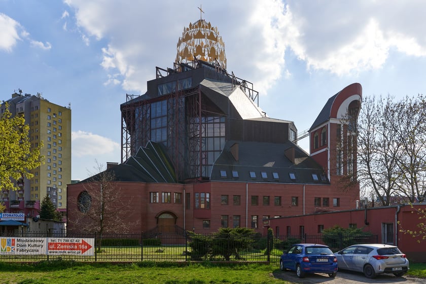 Rzymskokatolicki kości&oacute;ł pw. Opatrzności Bożej został konsekrowany w 2015 roku, ale jego budowa jeszcze się nie zakończyła. Rozpoczęto ją de facto w roku 1983, ale ze względu m.in. na bagienne podłoże konieczna była zmiana projektu, kt&oacute;rej podjął się prof. Zipser. Prace budowlane wznowiono w roku 1989.
Dynamiczną bryłę wieńczy kopuła przypominająca koronę, pod kt&oacute;rą umieszczono w ścianie duże przeszklenia. Cechą charakterystyczną rozczłonkowanej budowli o plastycznych formach jest wnękowa fasada nawiązująca do manieryzmu. W jej g&oacute;rnej części, niczym pod czapką z daszkiem, osadzono nowoczesny witraż przedstawiający oko opatrzności.