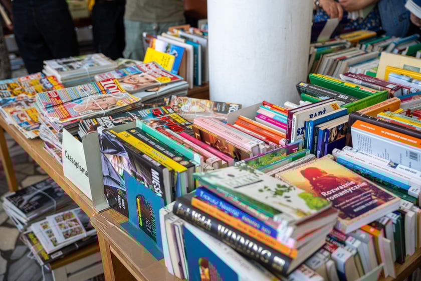Czytelnicy przeglądający książki i inne zbiory wystawione na sprzedaż w Dolnośląskiej Bibliotece Publicznej w rynku