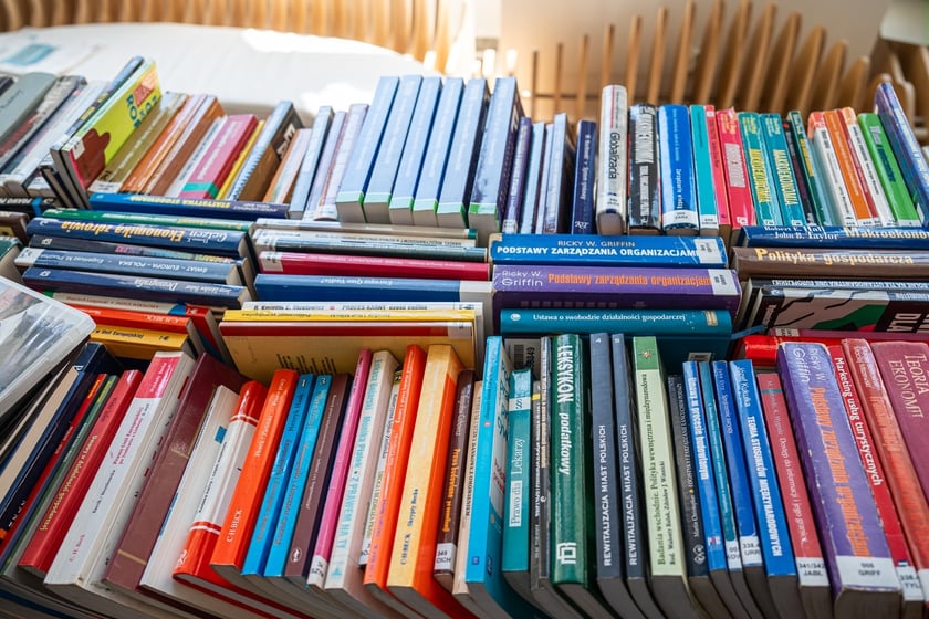 Czytelnicy przeglądający książki i inne zbiory wystawione na sprzedaż w Dolnośląskiej Bibliotece Publicznej w rynku
