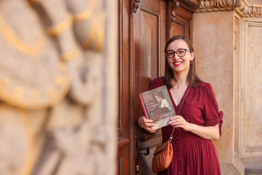Na zdjęciu Karolina Dzimira-Zarzycka z książką &bdquo;Własna pracownia&rdquo; przy kamienicy, w kt&oacute;rej mieszkała wrocławska malarka Hanna Krzetucka-Geppert