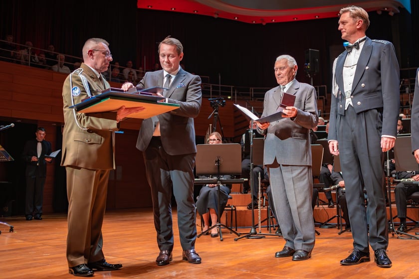 Koncert jubileuszowy na 75-lecie Orkiestry Reprezentacyjnej Wojsk Lądowych w NFM - wizeprezydent Wrocławia Michał Młyńczak wręczył na scenie odznaczenia