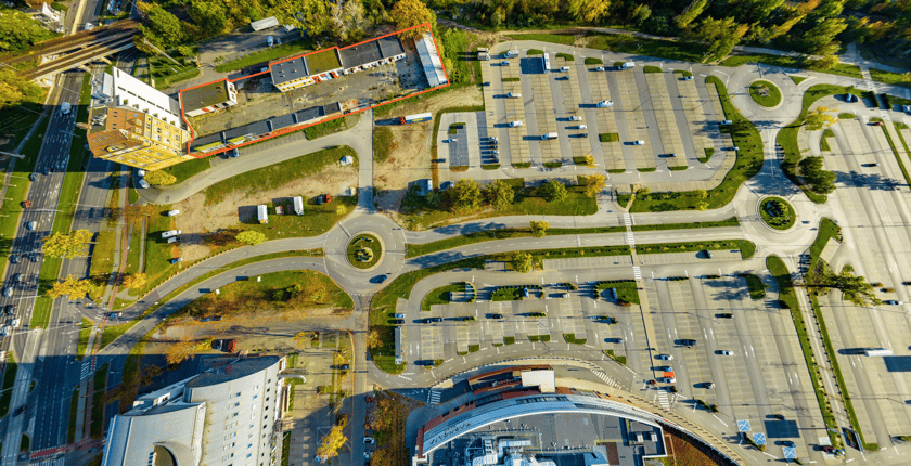 Zdjęcie lotnicze z zaznaczonym miejscem, gdzie powstanie nowa inwestycja mieszkaniowa pomiędzy parkingiem centrum handlowego Magnolia Park a towarowymi torami  kolejowymi