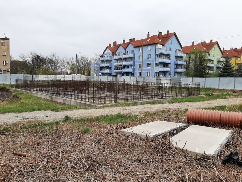 fundamenty budynku otoczone ogrodzeniem z blachy