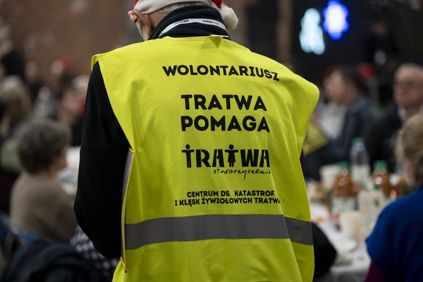 Wolontariusz w ż&oacute;łtej kamizelce, pomagający z organizacji Wigilii Pełnej Ciepła w Czasoprzestrzeni. Zdjęcie archiwalne z 2024 roku.