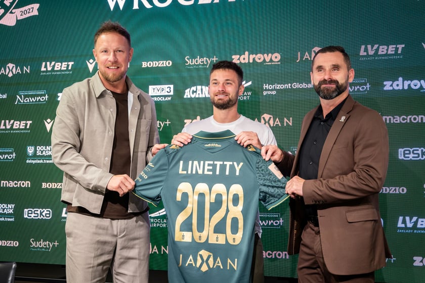 Powiększ obraz: Rafał Grodzicki, Karol Linetty i Remigiusz Jezierski trzymają koszulkęŚląska Wrocław z nazwiskiem piłkarza.