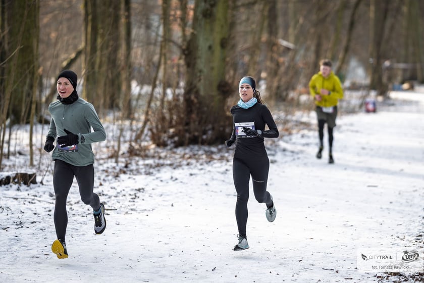 Powiększ obraz: Biegacze w zimowym lesie podczas zawodów City Trail.