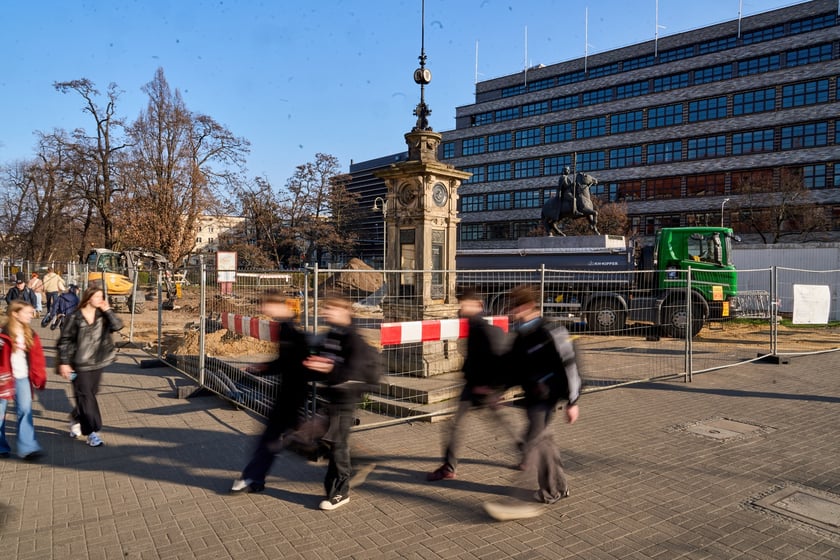 Wykopki pod rośliny przy konnym pomniku Bolesława Chrobrego, na tle Renomy