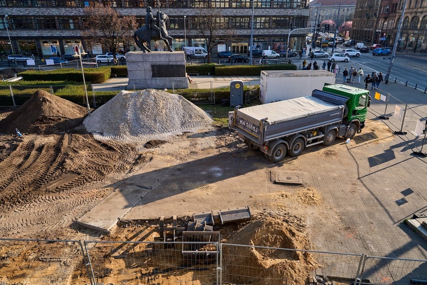 Wykopki pod rośliny przy konnym pomniku Bolesława Chrobrego, na tle Renomy