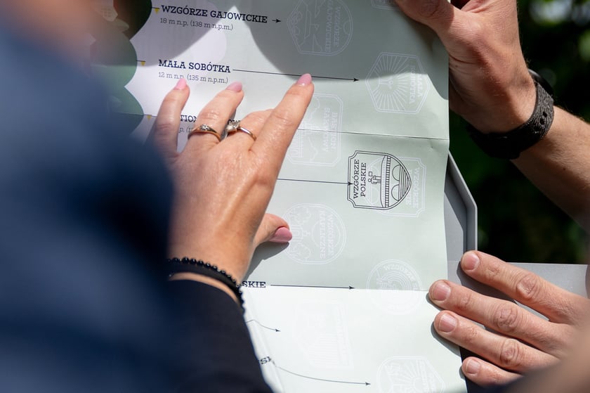 Konferencja prasowa na wzgórzu Polskim zapowiadająca miejską zabawę w zdobywanie Korony Górek Wrocławia. Pieczątka ze wzgórzem Polskim przybita na dedykowanej mapie