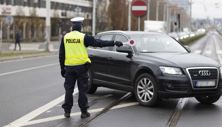 Zdjęcie archiwalne, ilustracyjne: policjant zatrzymuje samochód  