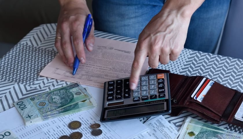 Na zdjęciu banknoty i monety leżące na stole. Sprawdź, jak rozliczyć podatki we Wrocławiu! 