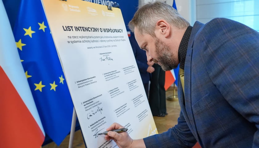 Podpisanie listu intencyjnego w sprawie powołania Dolnośląskiego Akademickiego Korpusu Ochrony Ludności (DAKOL). Wrocław, 21.07.2026. Podpis składa prof. Kamil Staniec, prorektor ds. kształcenia PWr.