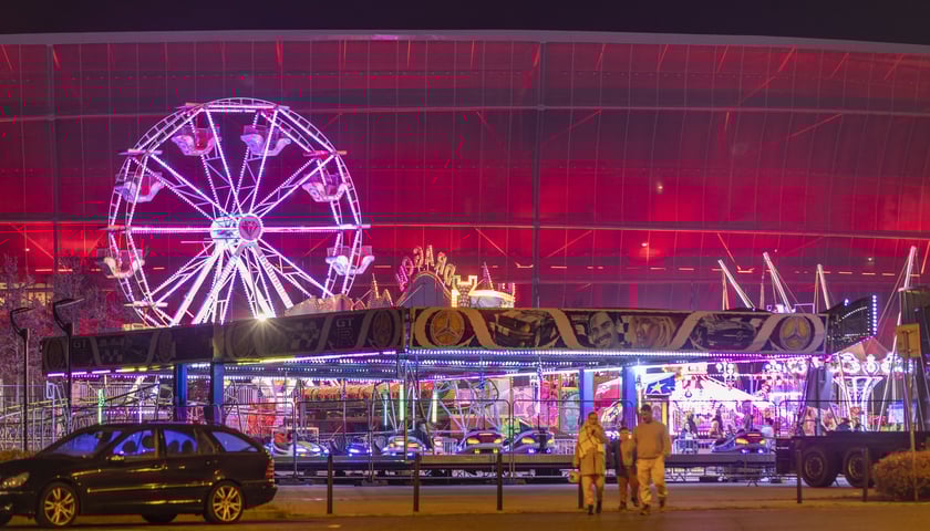 wesołe miasteczko przy Tarczyński Arena Wrocław, na zdjęciu koło młyńskie na tle stadionu nocą