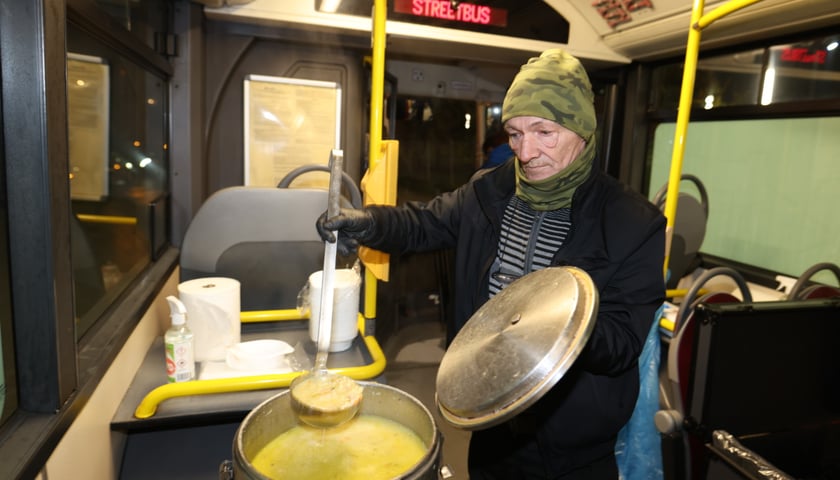 Na zdjęciu wnętrze Streetbusa - to autobus, w którym wydawane są zimą ciepłe posiłki dla osób bezdomnych i potrzebujących. Na zdjęciu widać mężczyznę, który nalewa zupę