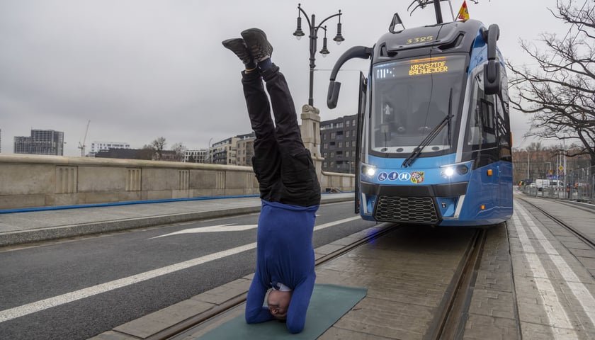 Na zdjęciu: kierownik Wojciech Kaim stojący na głowie przed tramwajem na moście Pomorskim 