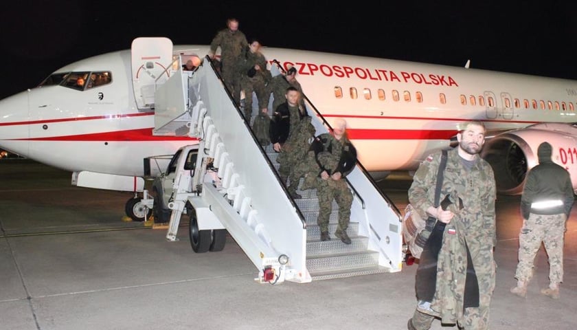 Na zdjęciu samolot oraz wysiadający z niego wojskowi medycy