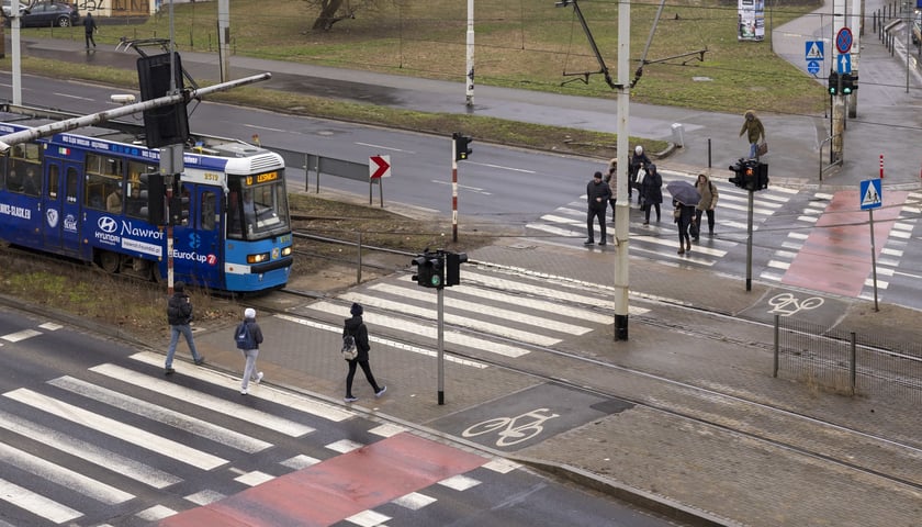 Na zdjęciu: piesi na przejściu przez torowisko i stojący przed nim tramwaj 10 (plac Powstańców Warszawy)
