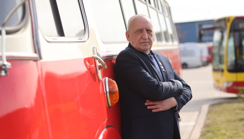 Na zdjęciu: Marek Kapciuch oparty plecami o stary autobus
