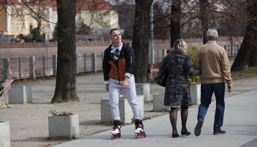 Na zdjęciu: mężczyzna na rolkach i spacerująca para na bulwarze nad Odrą