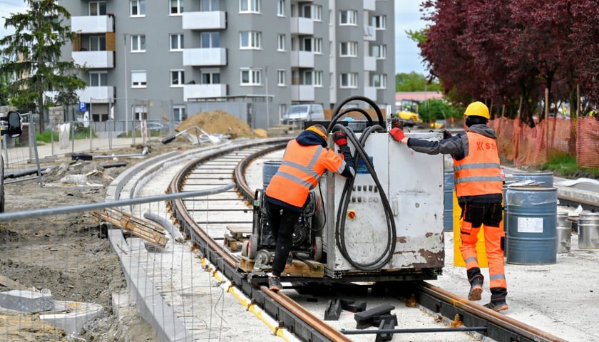 Prace na ul. Rogowskiej idą pełną parą (za zdjęciu dwóch pracowników na torach). Gdyby roboty nie trwały na zakręcie, można by powiedzieć, że to już ostatnia prosta.