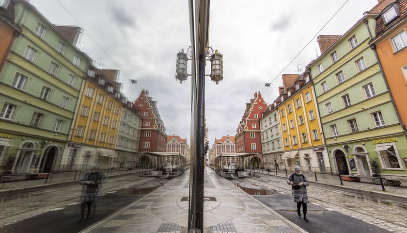 Kobieta idąca chodnikiem ulicy Ruskiej, odbicie w lustrze