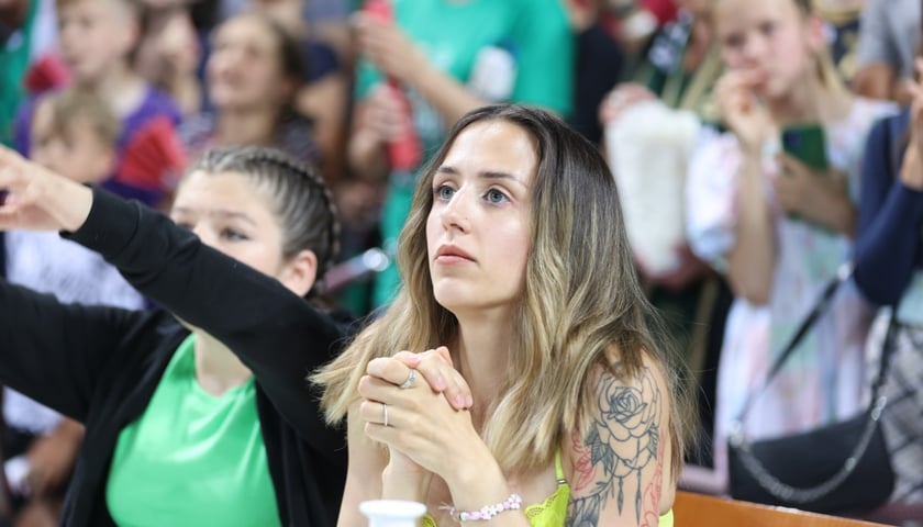 Kobieta ze złożonymi pod twarzą dłońmi na trybunach Hali Stulecia podczas piątego meczu finałowego pomiędzy Śląskiem Wrocław a Kingiem Szczecin