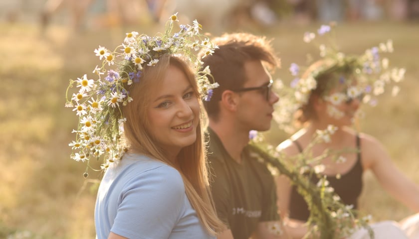 Noc Świętojańska w OPT Zamek. Piękna blondynka w wianku z kwiatów na pierwszym planie