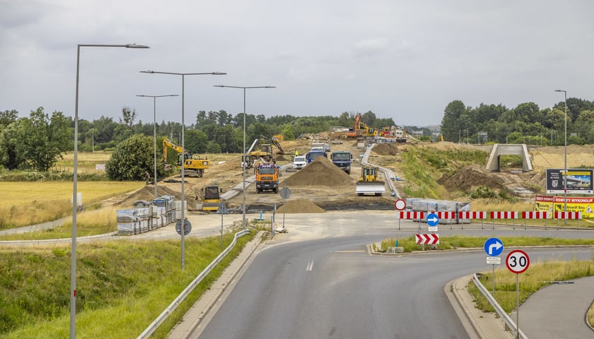 Koparki, spycharki i inne pojazdy budowlane na przygotowywanym wjeździe na wiadukt na trasie powstającego odcinka obwodnicy Leśnicy