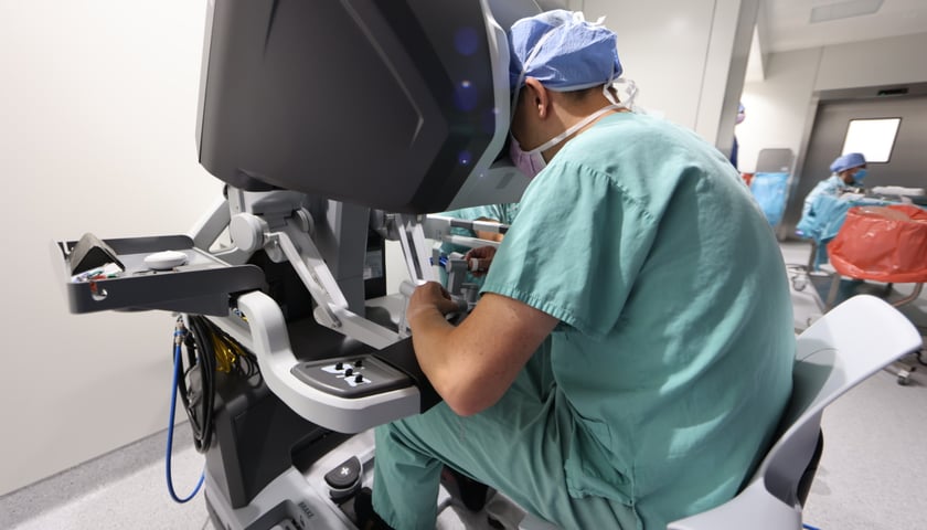 Lekarz sterujący robotem na sali operacyjnej w USK