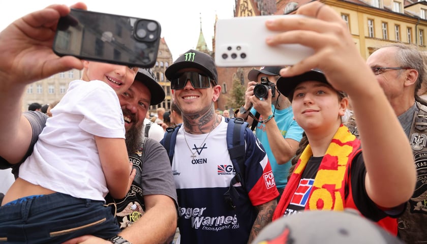 Kibice i Tai Woffinden w okularach słonecznych w trakcie robienia wspólnego zdjęcia