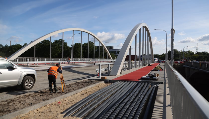 Na zdjęciu nowe mosty Chrobrego w budowie w pracownikiem w pomarańczowej kamizelce
