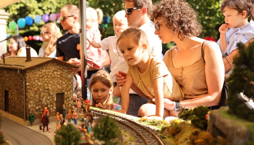 Dzieci i rodzice przy makiecie z figurkami w parku Staromiejskim. Wrocławski Festiwal Krasnoludków.