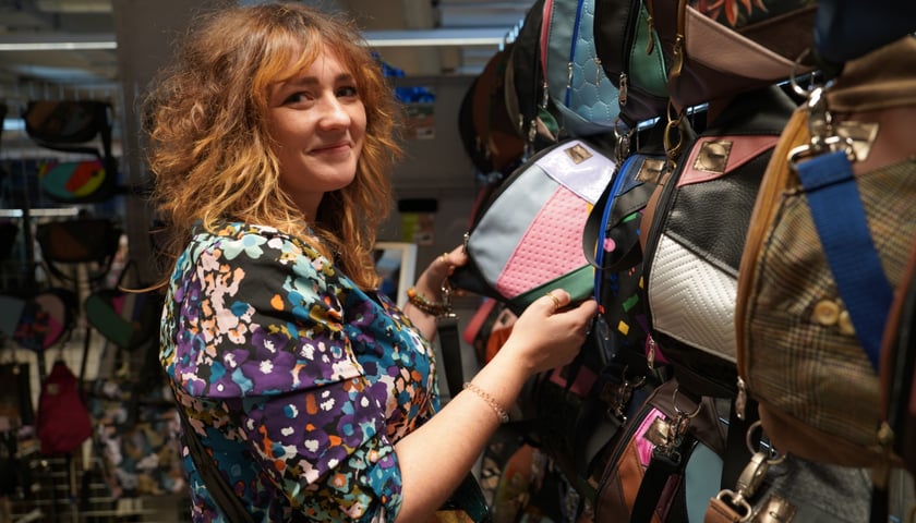 Uśmiechnięta kobieta na stoisku z "nerkami" i torbami podczas Targów Dobry Design